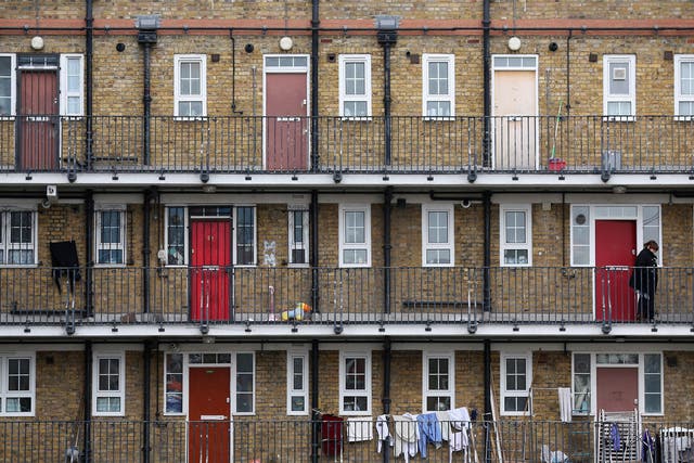 A woman looks out from a residential development in the London borough of Tower Hamlets