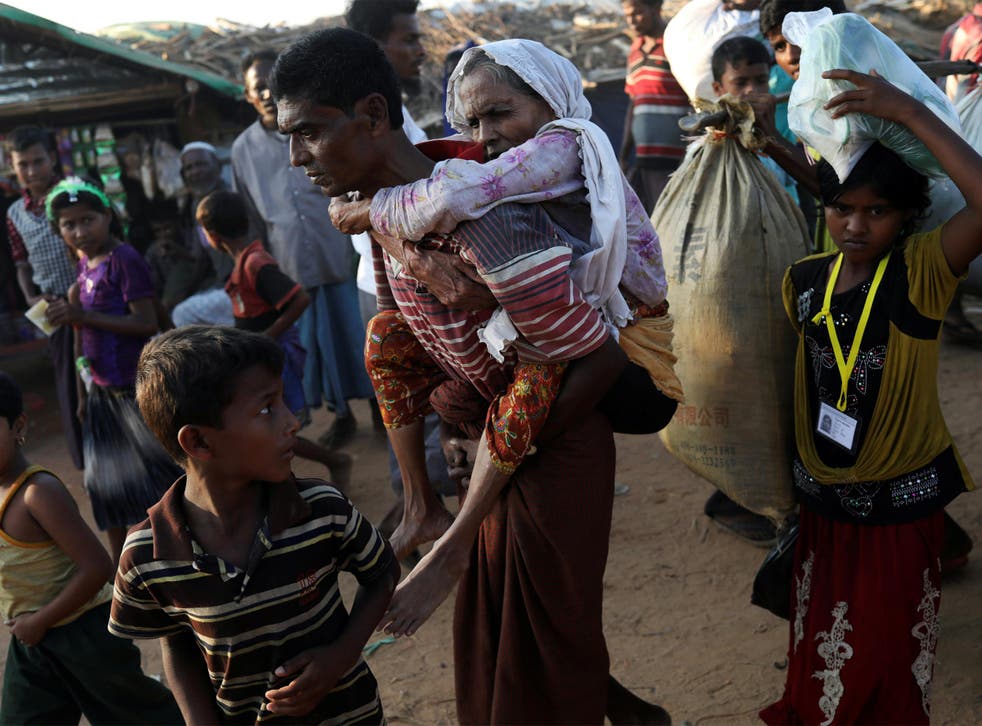 Rohingya refugee Suray Khatun, 70, is carried by her son Said-A-Lam, 38, as they enter Kutupalong refugee camp, near Cox's Bazar, Bangladesh a day after crossing the Myanmar border