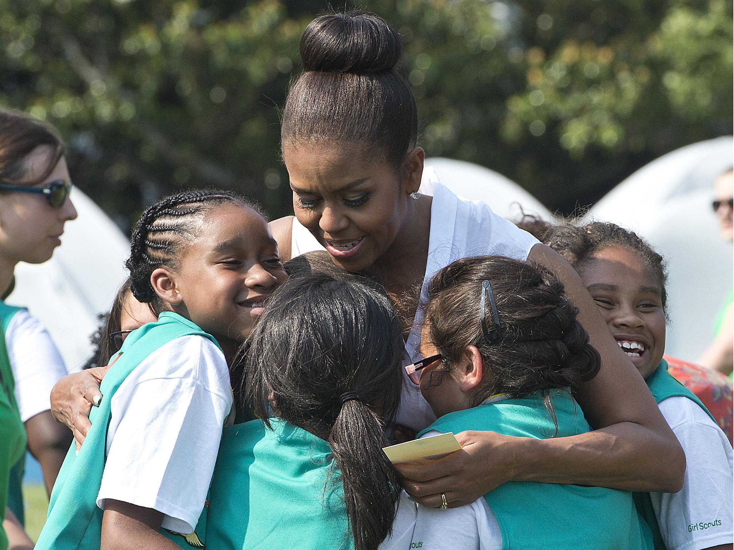 Girl Scouts hug former First Lady Michelle Obama at the White House