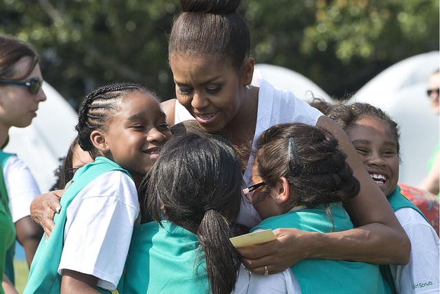 Girl Scouts hug former First Lady Michelle Obama at the White House