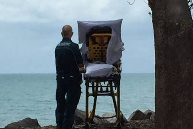 Paramedic Graeme Cooper alongside a woman in a hospital bed overlooking the sea