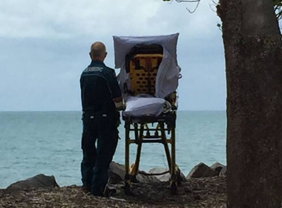 Paramedic Graeme Cooper alongside a woman in a hospital bed overlooking the sea