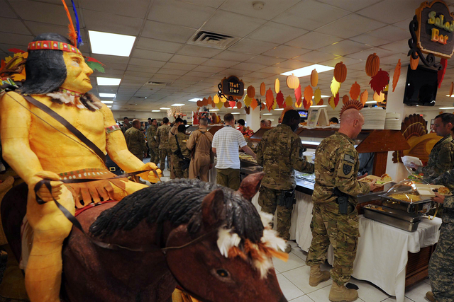 A Native American on horseback is seen as US soldiers wait in line for their Thanksgiving Day meal