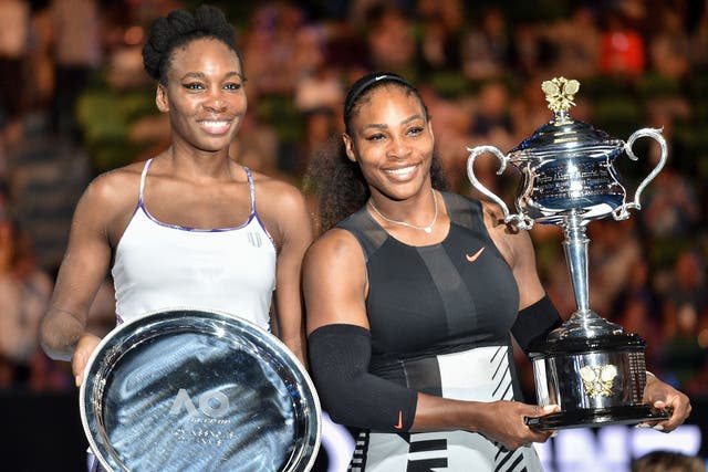 <p>Serena Williams holds the 2020 Australian Open trophy next to her sister, Venus, who she beat in the women's singles final</p>