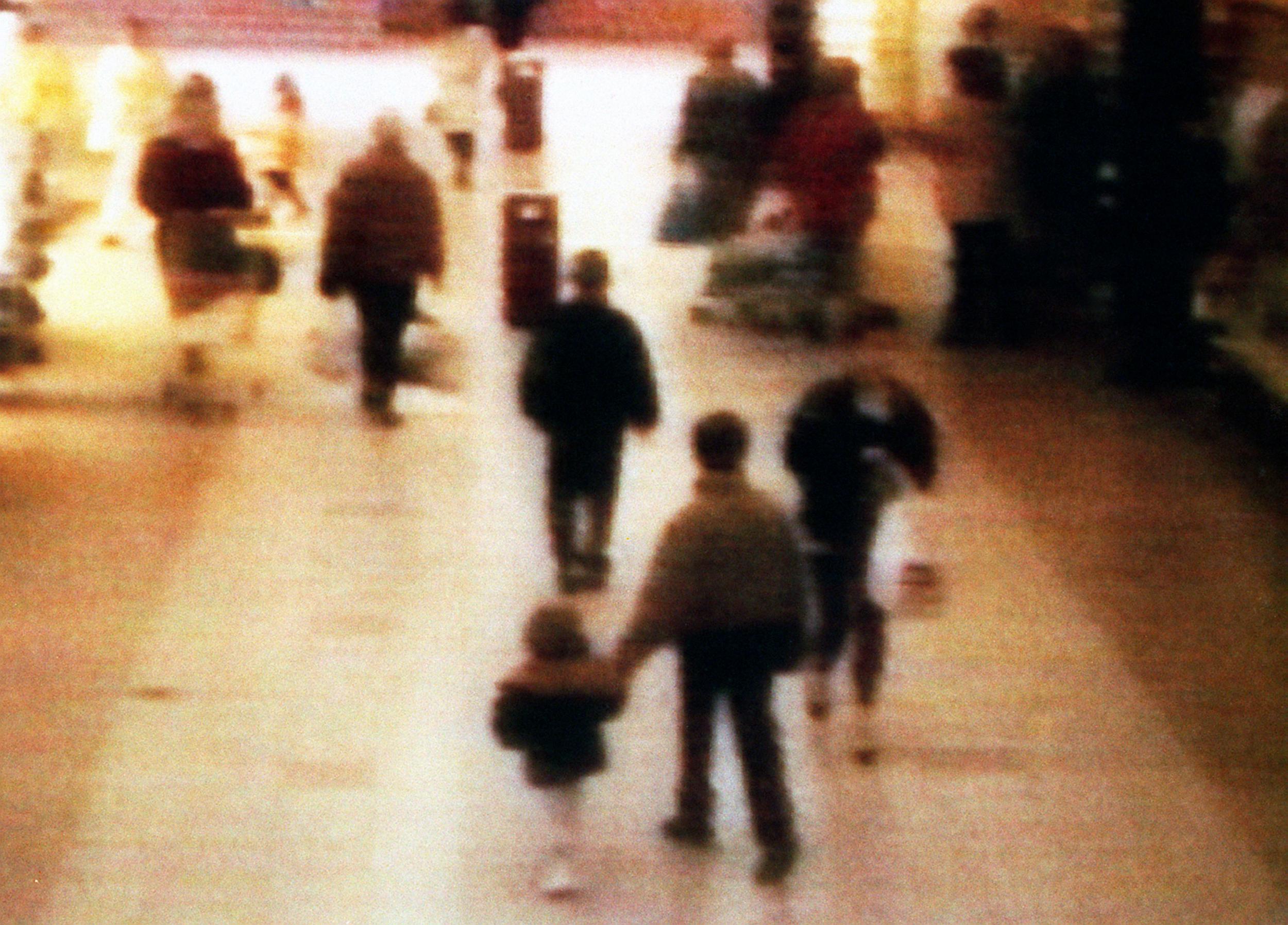 A video still of James Bulger, aged 2 years old, being led away in the 'New Strand' shopping centre