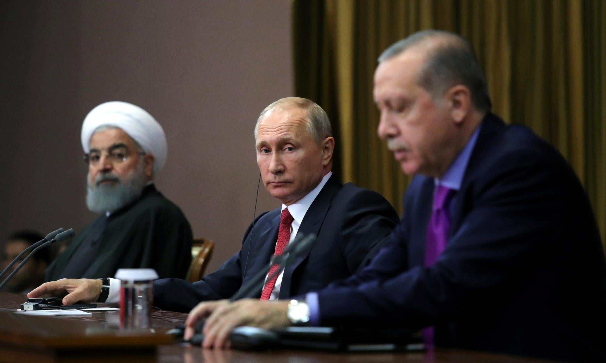 Russian President Vladimir Putin is flanked by Iranian President Hassan Rouhani (l) and Turkish Premier Recip Tayyip Erdogan at the Sochi summit this week