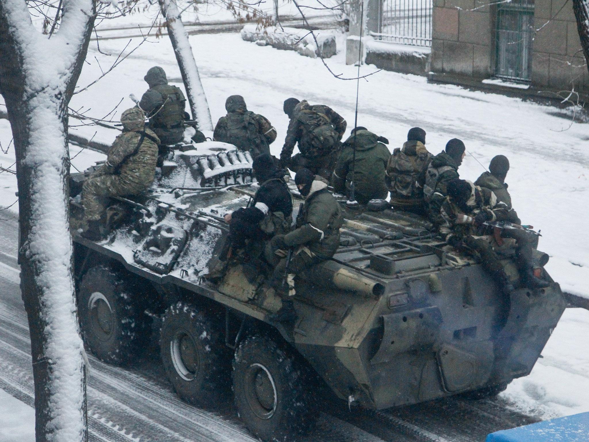 Armed men without insignia ride on a personnel carrier along a street in Luhansk city, Ukraine, on 23 November 2017