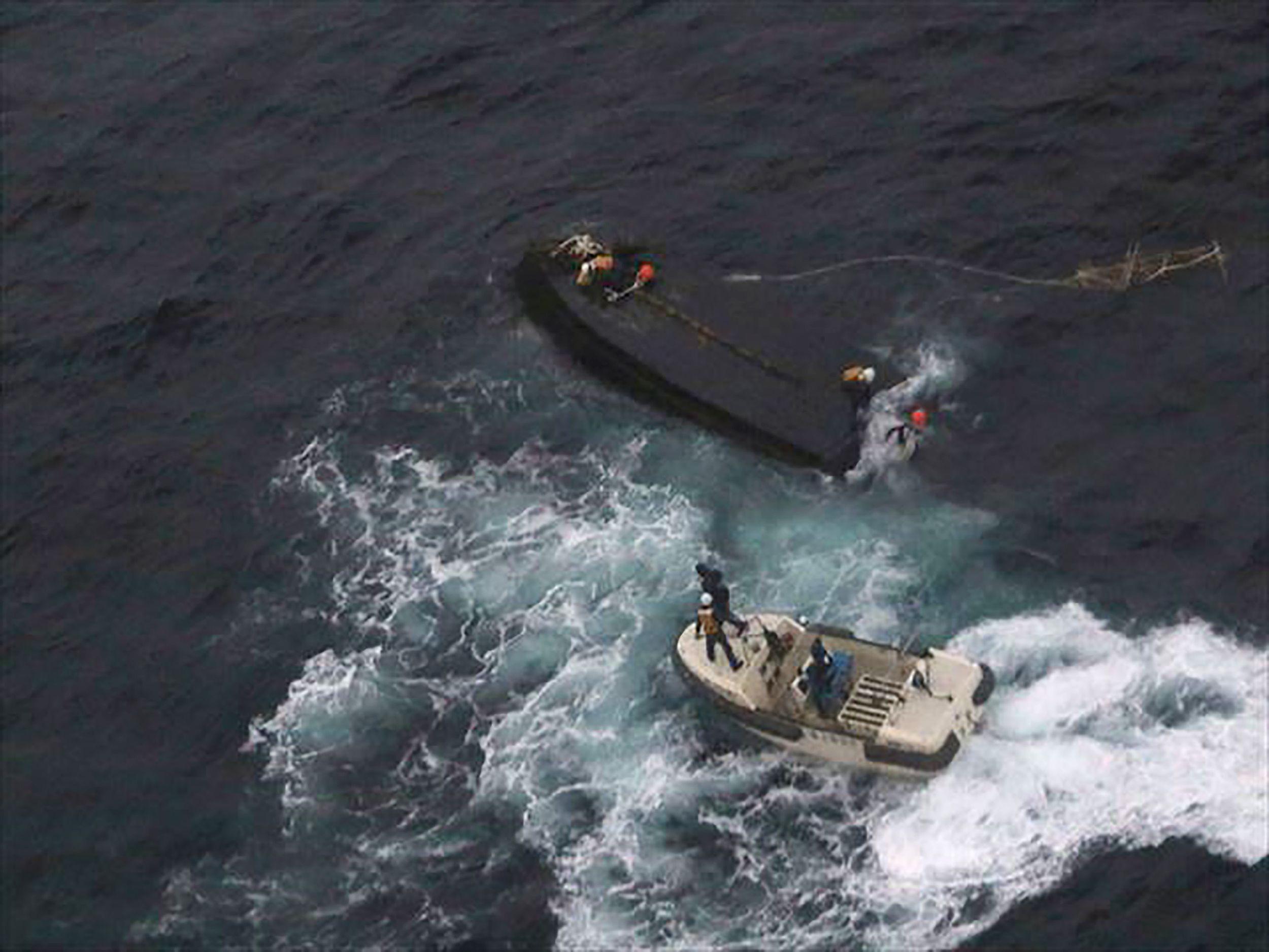 A Japanese Coast Guard rescue team approaching a capsized North Korean boat on the Sea of Japan about 225 miles north west of the Noto Peninsula in Ishikawa Prefecture