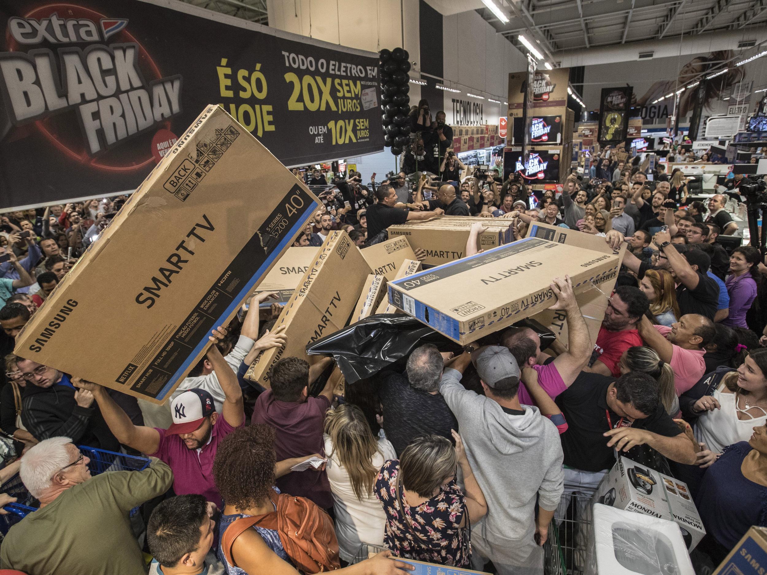 Dozens of Brazilians reach for television sets in a store in Sao Paulo, Brazil