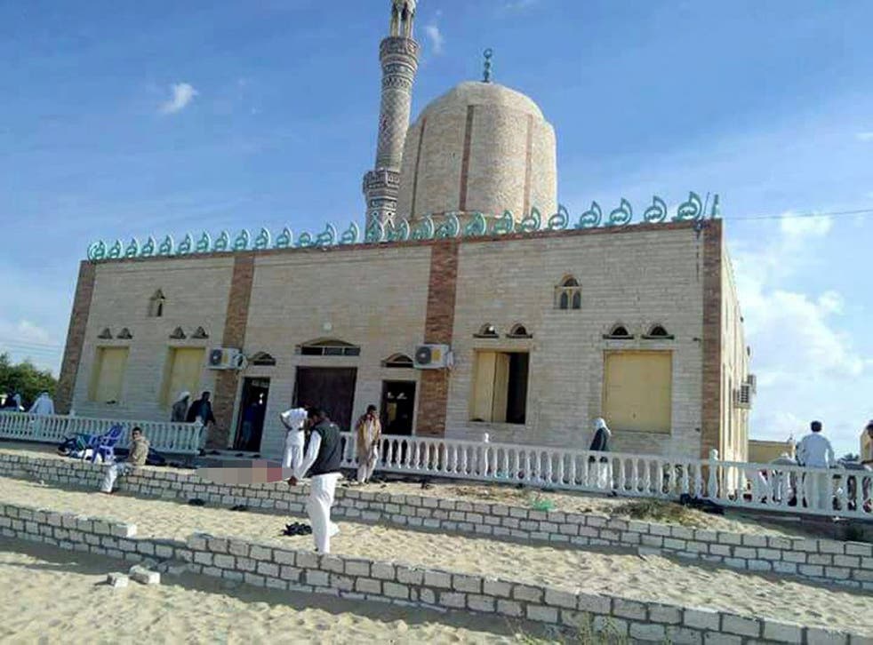 People walk outside a mosque that was attacked in the northern city of Arish, Sinai Peninsula
