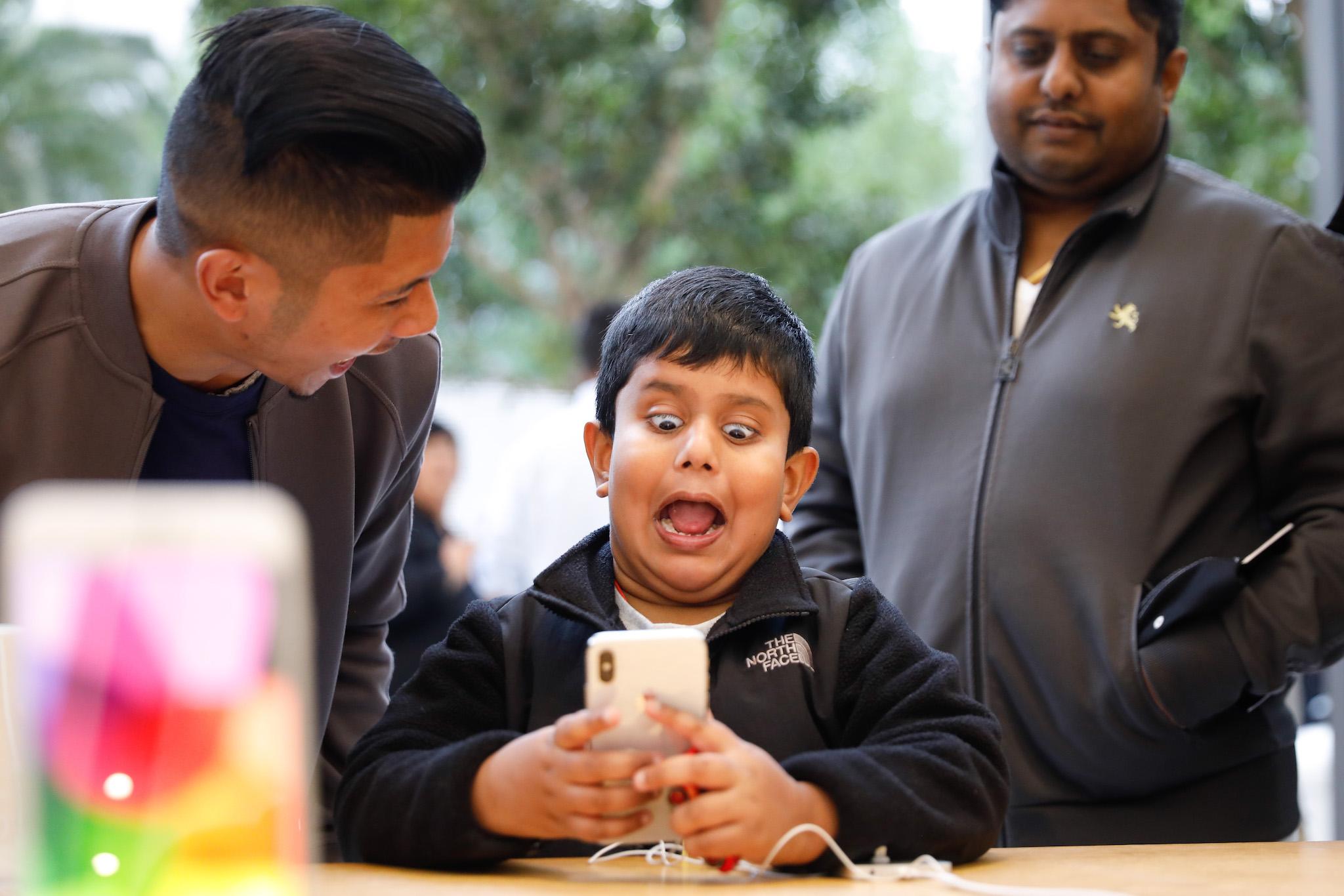 A boy makes faces while testing out the Animoji feature on an iPhone X at the Apple Store Union Square on November 3, 2017, in San Francisco, California