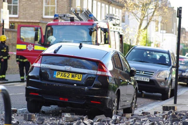 A mother and her baby had a narrow escape when rubble fell from the top of a tower block and into the road in Hackney, east London