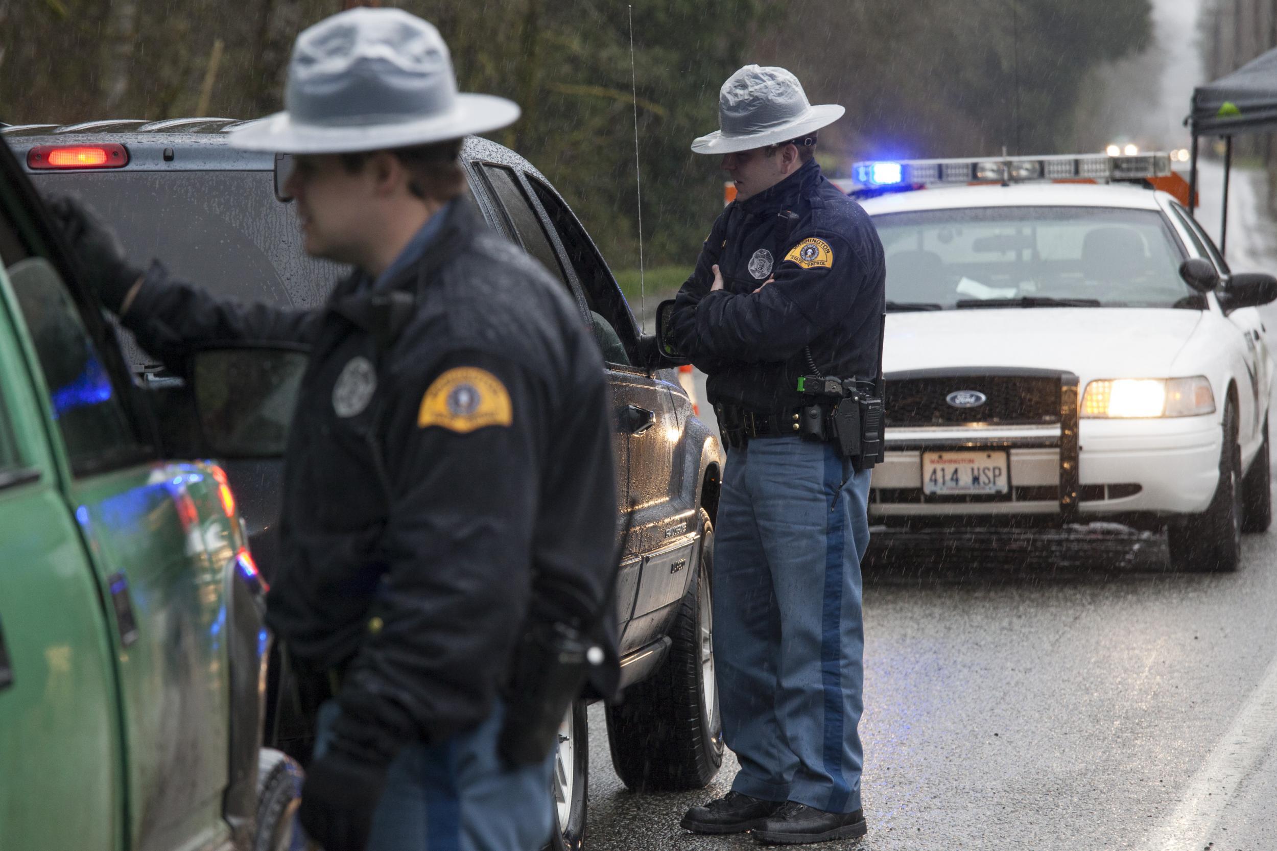 Washington State Patrol troopers stop vehicles at a road block on a local highway