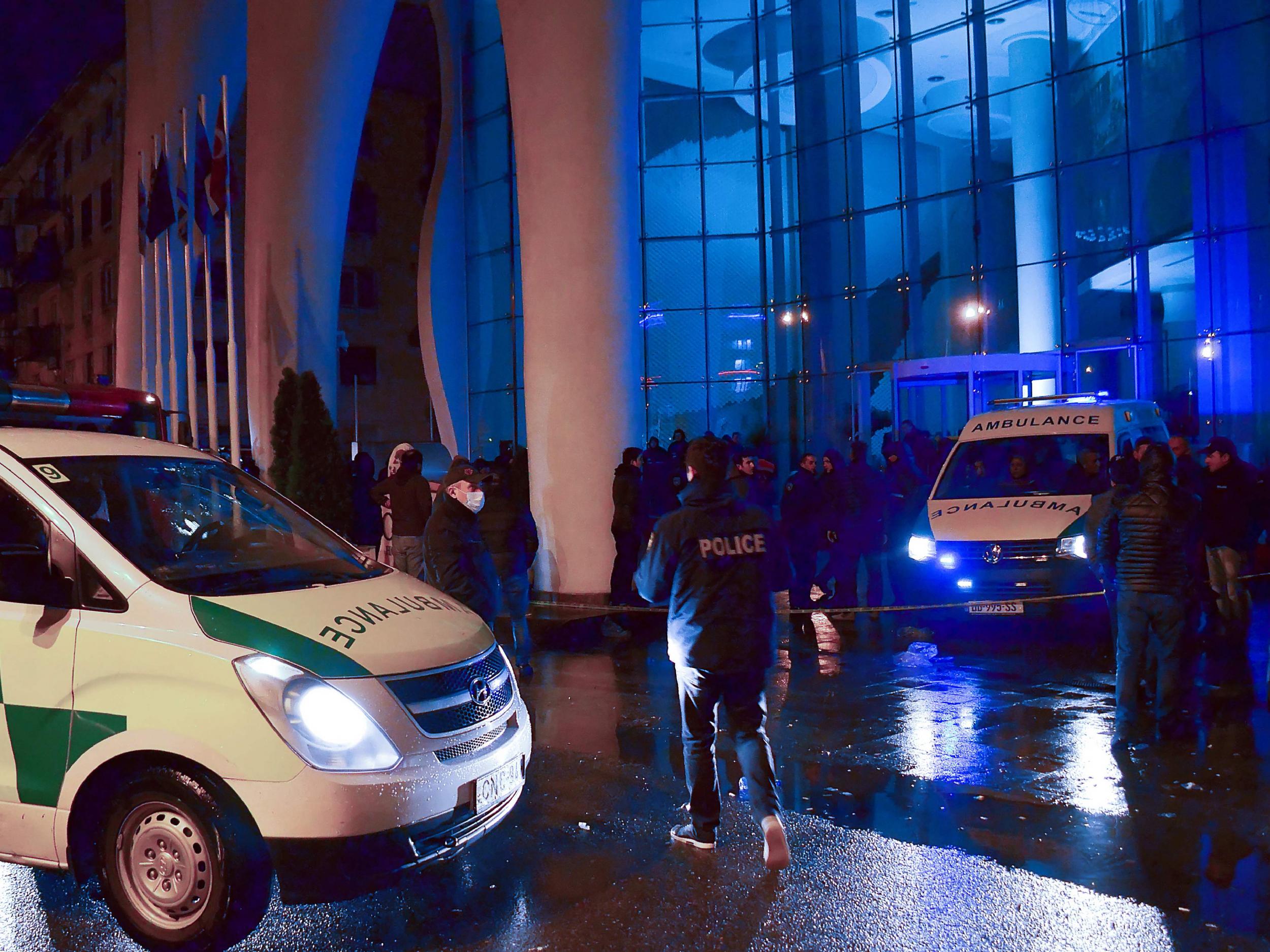 Georgian police investigators and ambulance cars are seen in front of the Leogrand hotel in Georgia's Black Sea resort city of Batumi