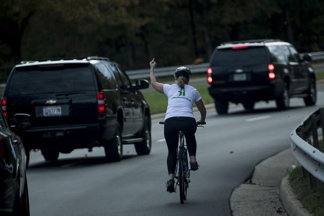 Ms Briskman gestures with her middle finger as a motorcade with US President Donald Trump departs Trump National Golf Course October 28, 2017