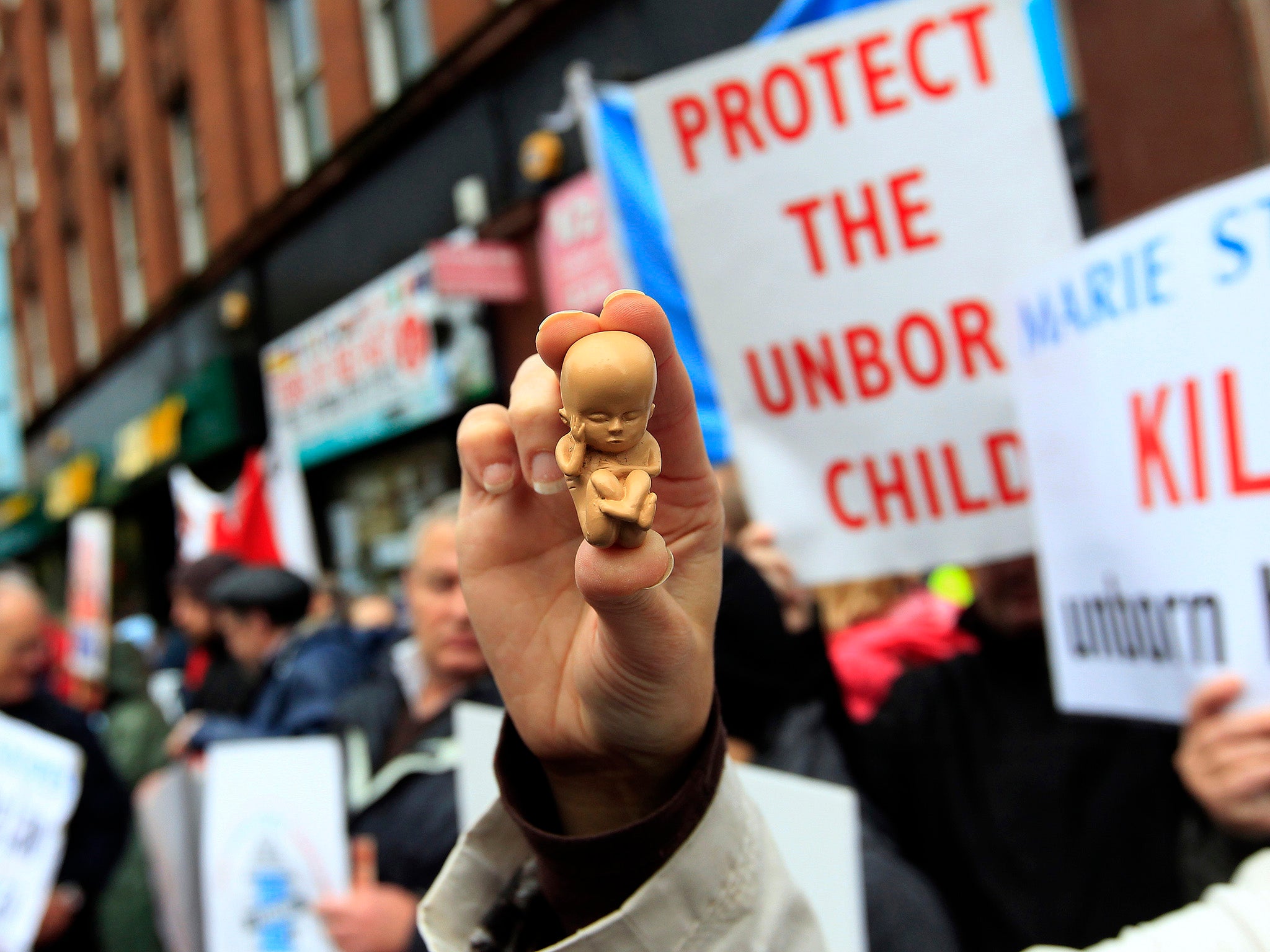A pro-life campaigner holds up a model of a 12-week-old embryo