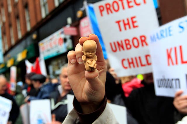 <p>A pro-life campaigner holds up a model of a 12-week-old embryo</p>