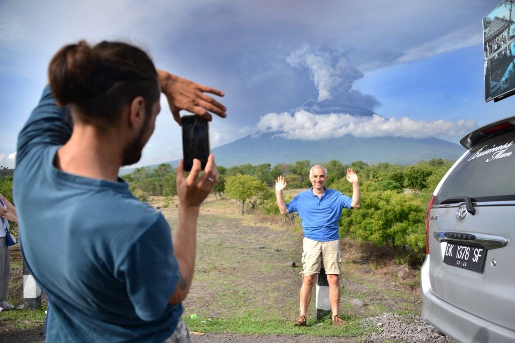 A tourist in front of Mount Agung on Monday