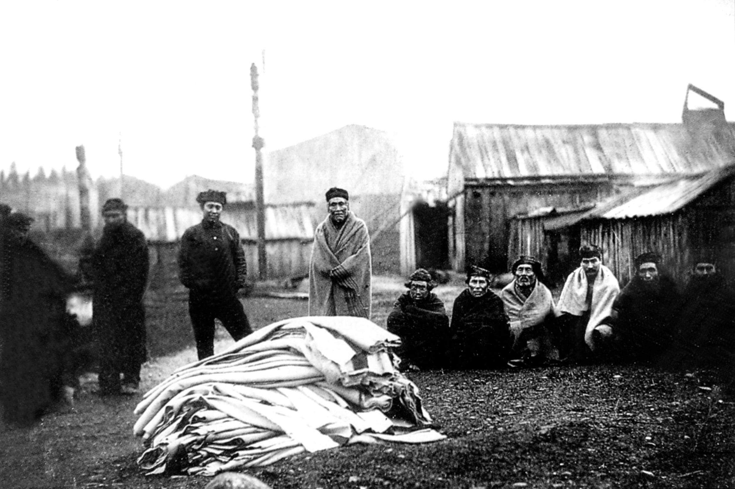 Kwakiutl Native Americans gather around a blanket heap during a late 19th-century potlatch ceremony at Fort Rupert, British Columbia