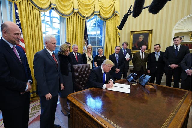 US President Donald Trump signs an executive order on ethics commitments by the executive branch appointees in the Oval Office on 28 January 2017
