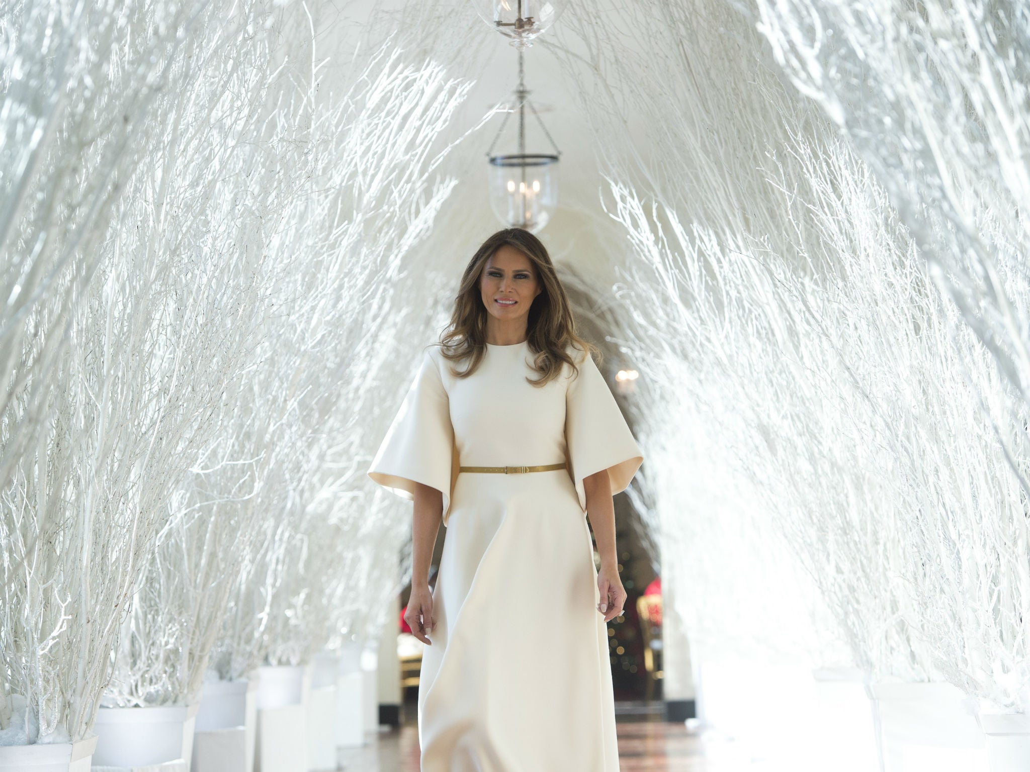 First Lady Melania Trump walks through Christmas decorations in the East Wing