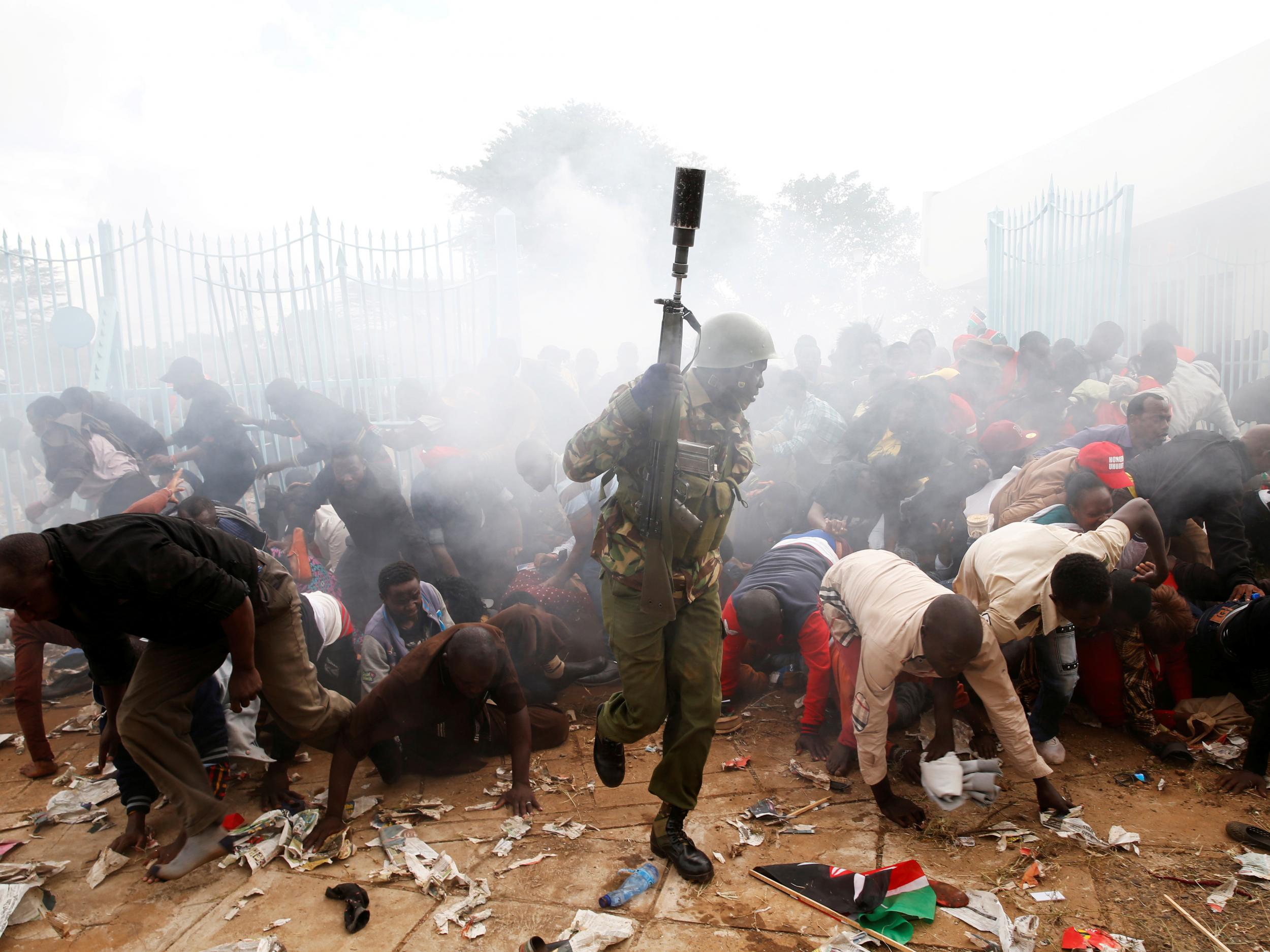 People fall as police fire tear gas to try control a crowd trying to force their way into a stadium to attend the inauguration of President Uhuru Kenyatta at Kasarani Stadium in Nairobi (Reuters)
