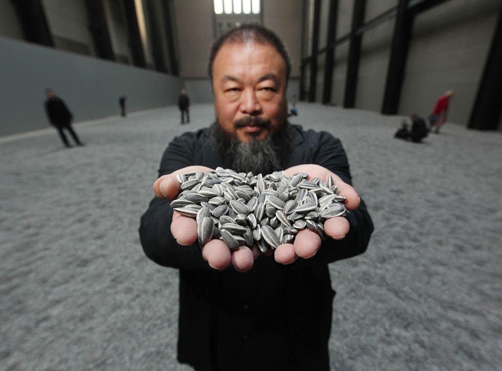 Ai Weiwei holds some seeds from his Unilever Installation 'Sunflower Seeds' at The Tate Modern in 2010