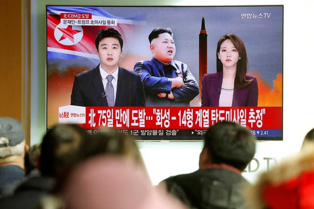 People watch a TV broadcasting a news report on North Korea firing what appeared to be an intercontinental ballistic missile that landed close to Japan from Seoul, South Korea