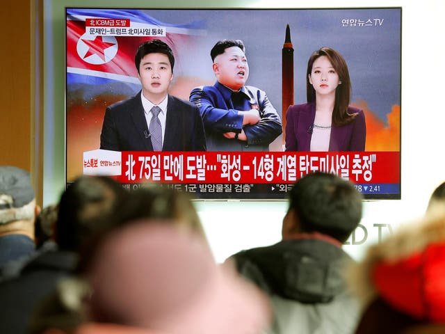 People watch a TV broadcasting a news report on North Korea firing what appeared to be an intercontinental ballistic missile that landed close to Japan from Seoul, South Korea