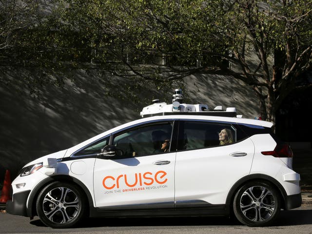 A woman smiles in the back seat of a self-driving Chevy Bolt EV car during a media event by Cruise, GM’s autonomous car unit, in San Francisco on November 28, 2017