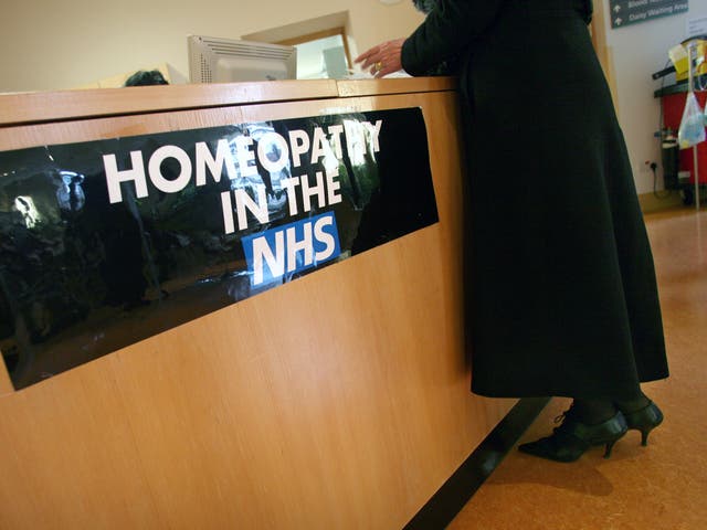 A women stands at the Homeopathy reception desk