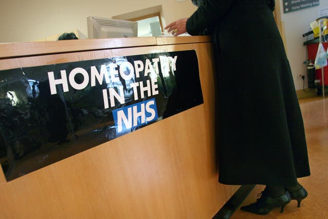 A women stands at the Homeopathy reception desk