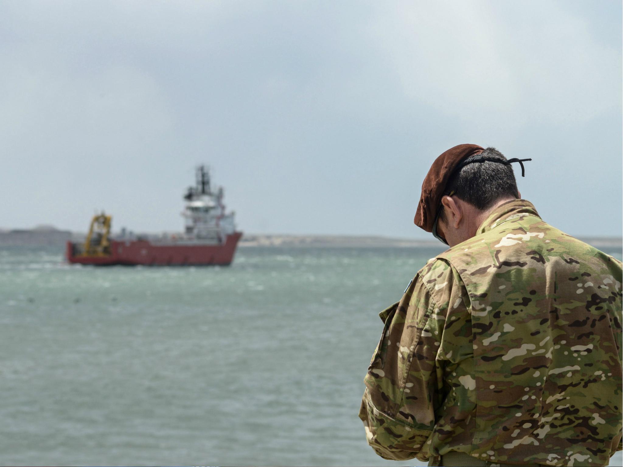 A member of the U.S. Navy stands at Comodoro Rivadavia harbour after the US Navy installed its deep diving rescue vehicle on the Sophie Siem vessel