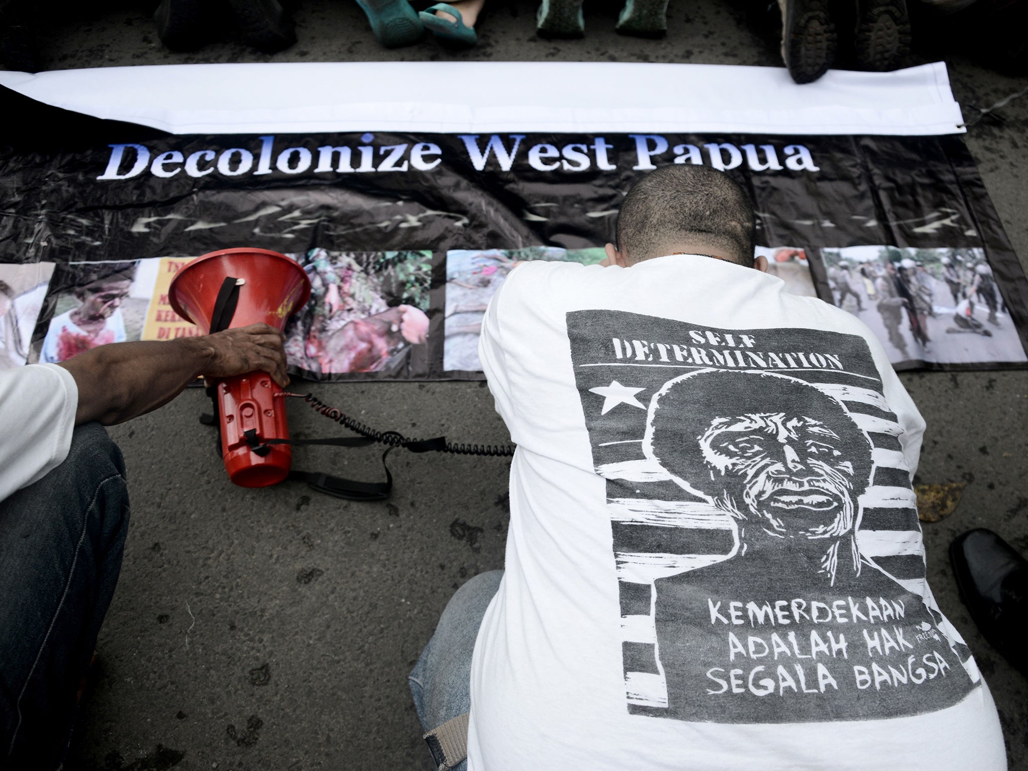 An Indonesian activist kneels before West Papuan pro-independence demonstrators in a symbolic gesture seeking forgiveness for their country’s occupation during a protest in Jakarta in April (Getty)