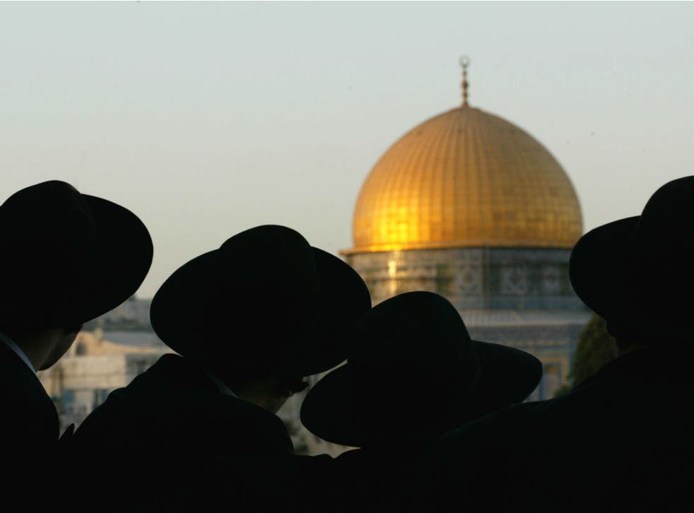 Ultra-Orthodox Jews look at the Dome of the Rock, one of the holiest sites for Muslims, in Jerusalem on August 8, 2002