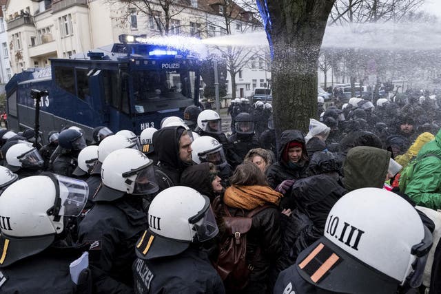 Police use a water cannon to clear a street blocked by demonstrators near the venue of the AfD convention in Hanover
