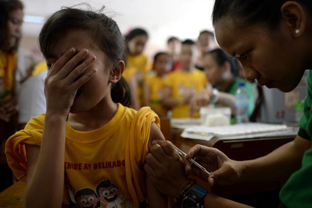 A student grimaces as a nurse administers an anti-dengue vaccine at Parang Elementary School in Marikina, west of Manila on 1 April, 2016