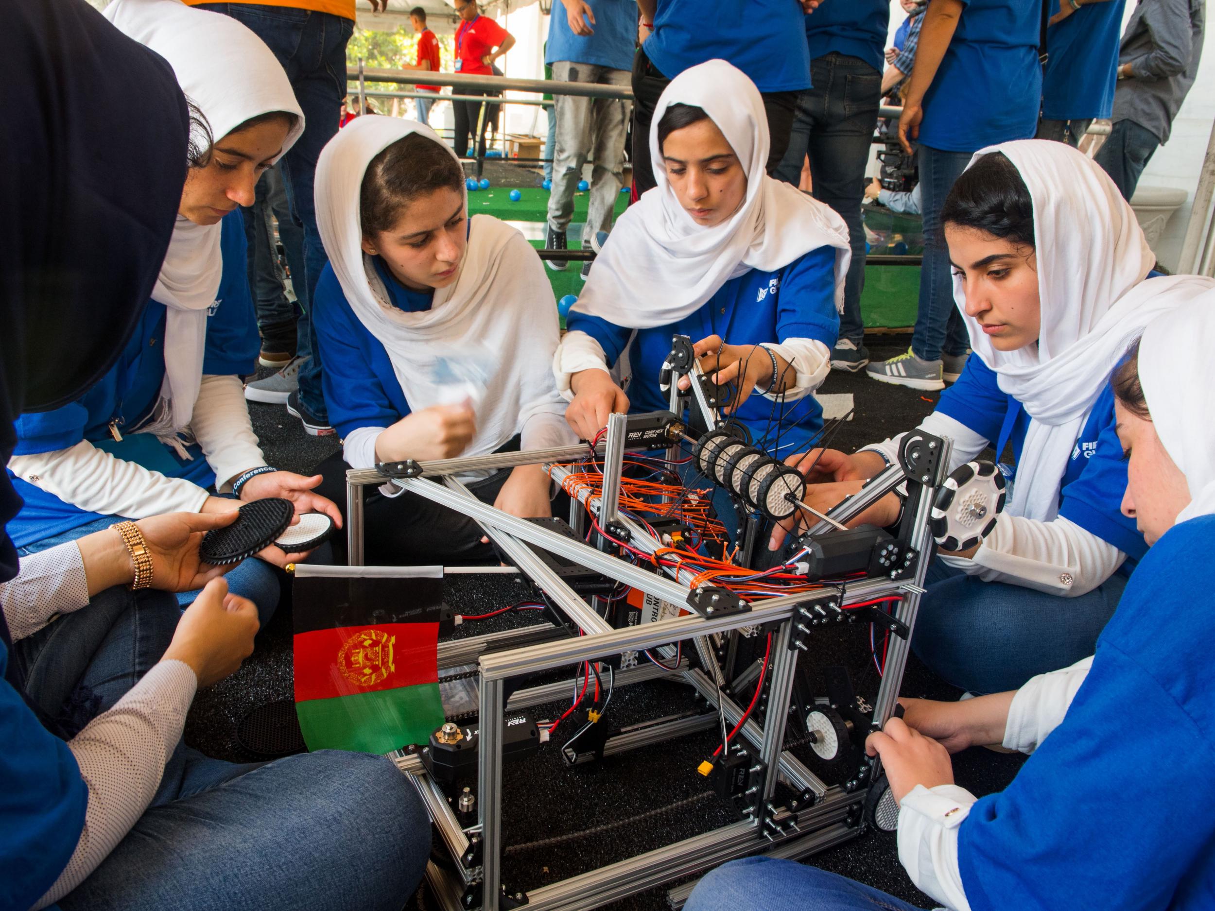 Members of the Afghan all-girls robotics team make adjustments to the team robot in the practice area on July 17, 2017