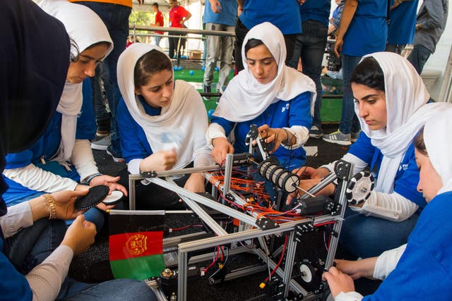 Members of the Afghan all-girls robotics team make adjustments to the team robot in the practice area on July 17, 2017