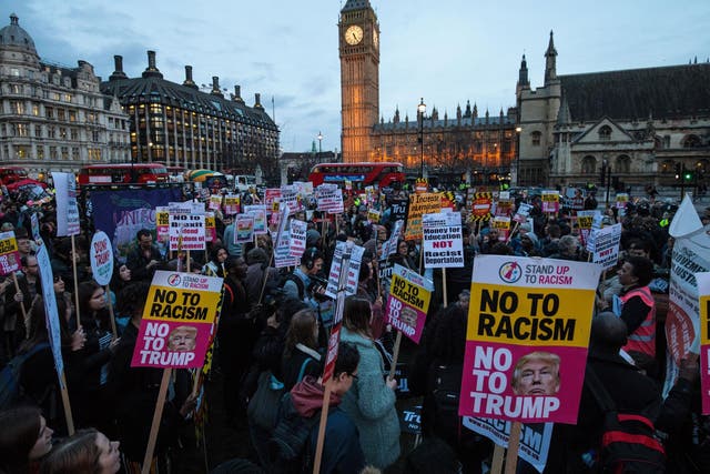 Protesters holding placards take part in a rally in Parliament Square in February 2017  against US president Donald Trump's state visit to the UK