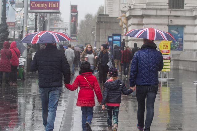 Pedestrians shelter from the rain on Westminster Bridge