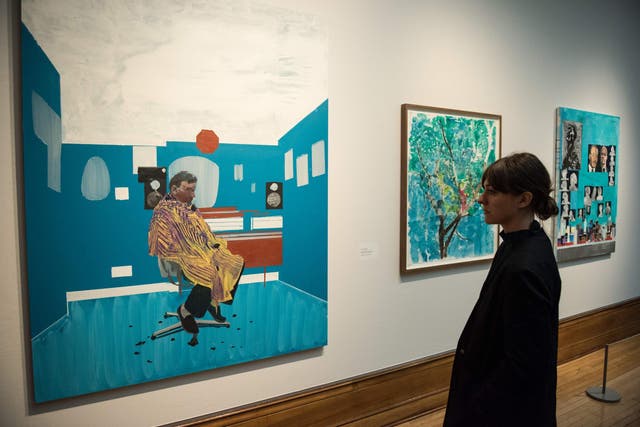 A woman views artworks by Hurvin Anderson, including 'Peter's Sitters III' (L).