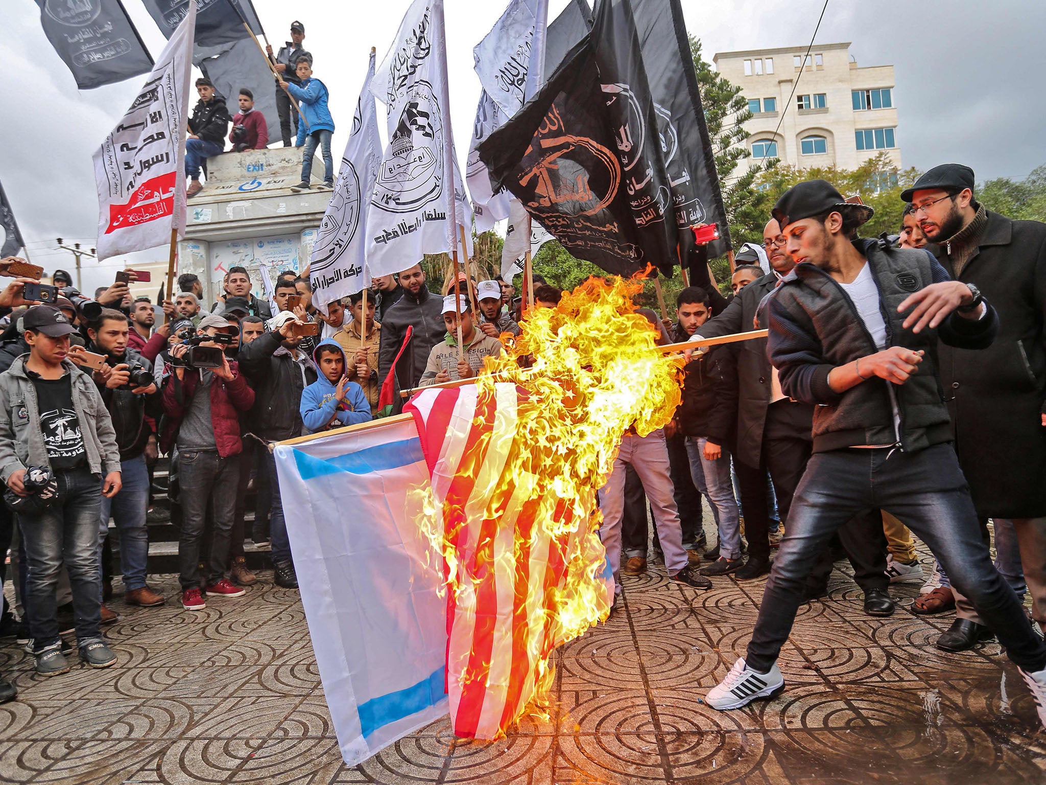 Palestinian protesters burn the US and Israeli flags in Gaza City in response to Trump's announcement