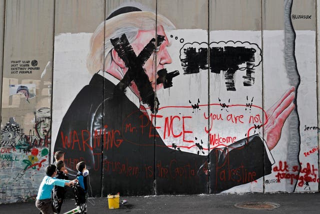 Vandalised graffiti depicting the US President is painted on Israel’s controversial separation barrier in the West Bank city of Bethlehem