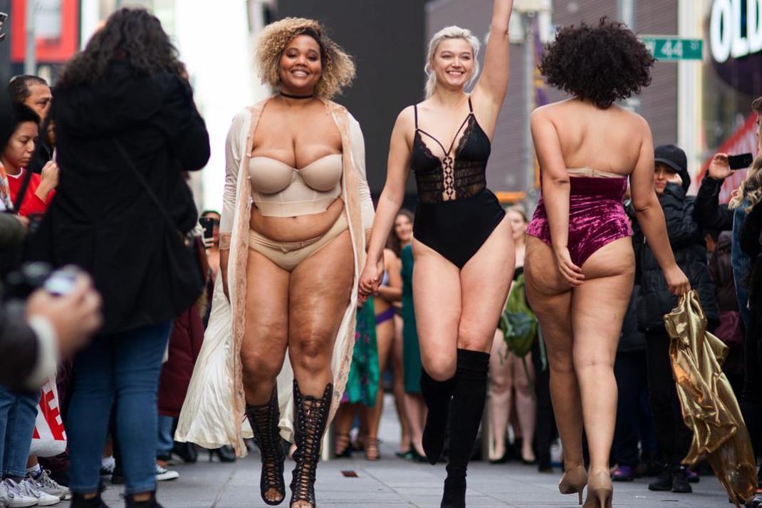 Models hold hands during "The Real Catwalk" fashion show in Times Square