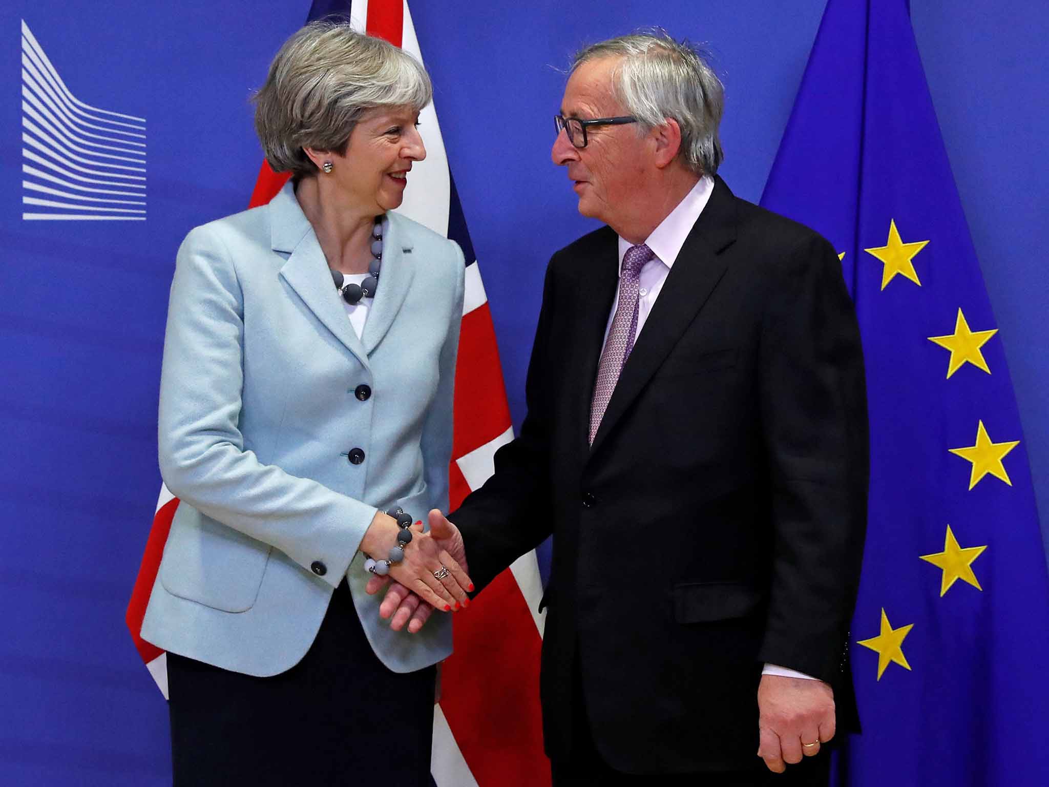 Theresa May shakes hands with EC President Jean-Claude Juncker as both parties agree to move onto trade talks