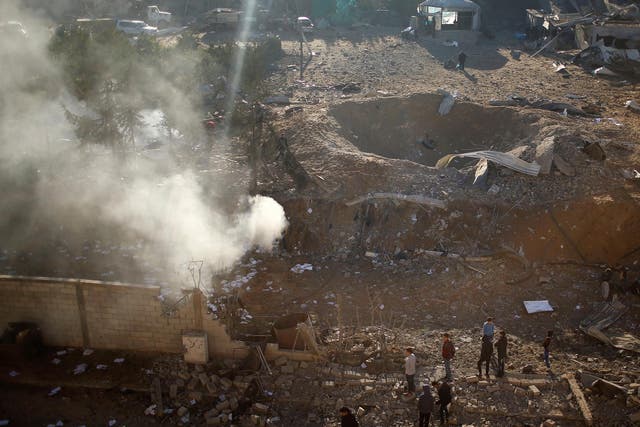 Palestinians look at a militant target that was hit in an Israeli airstrike in the northern Gaza Strip