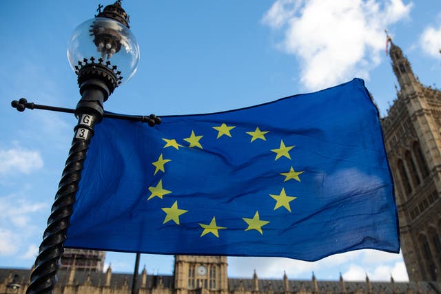 The EU flag flutters from a lamp post outside the Houses of Parliament