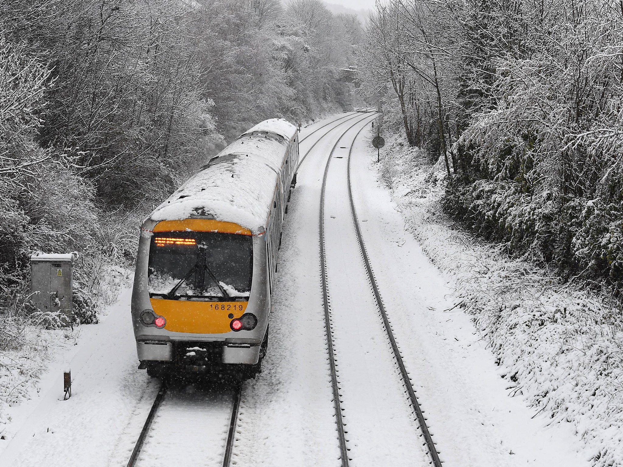 A train travels along snow covered tracks in High Wycombe