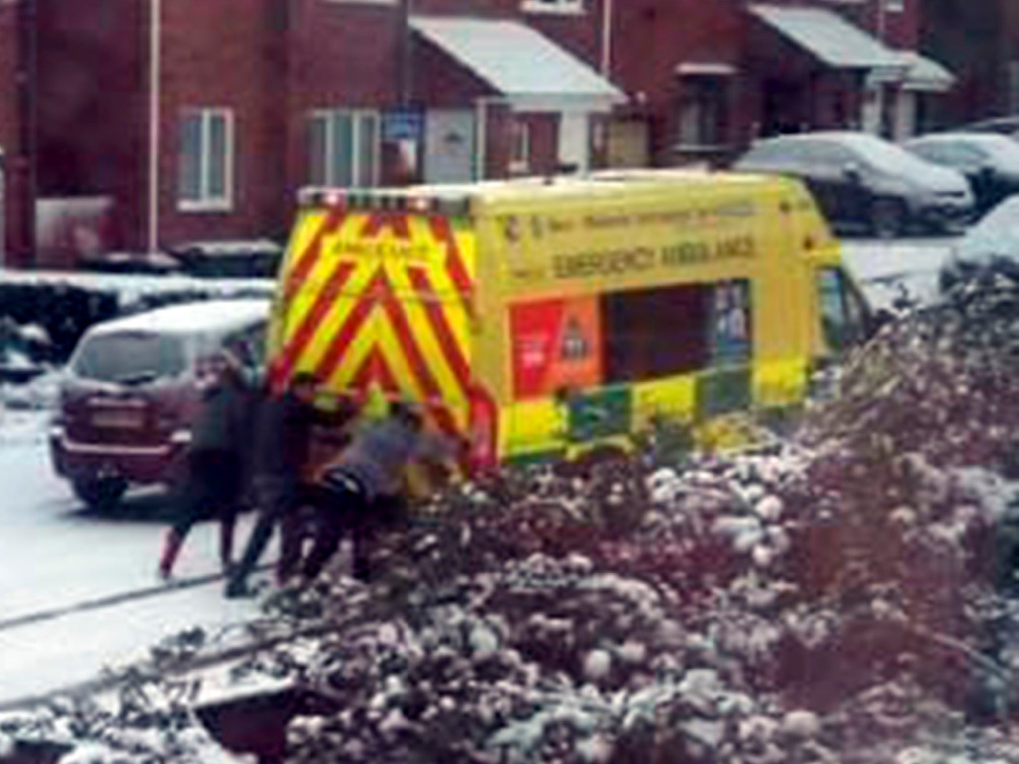 Three men help the ambulance in the snow in Ladywood, Birmingham